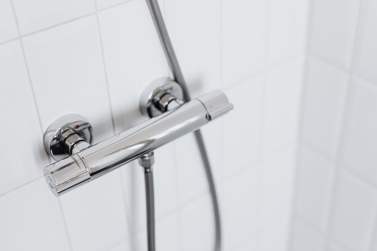 Chrome shower mixer on a tiled bathroom wall: bathroom plumbing for older Kharghar flats, Navi Mumbai