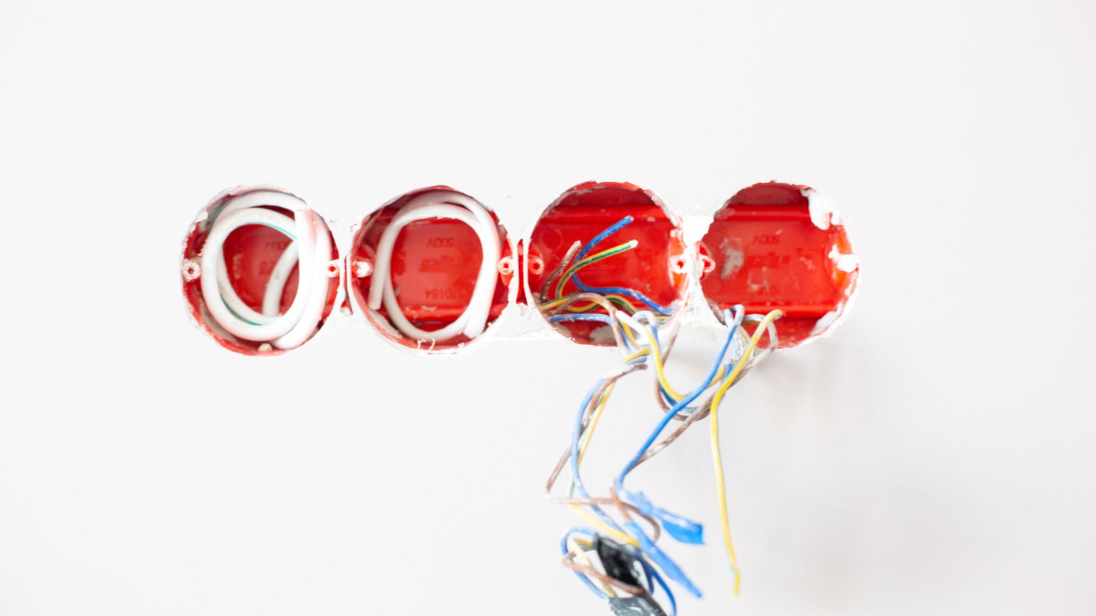 Close-up of exposed electrical wiring in wall sockets ready for installation. Ideal for home improvement contexts.